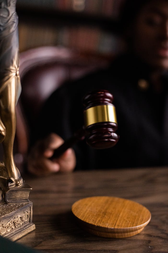 Close-up of a judge holding a gavel, symbolizing justice and law in a courtroom setting.