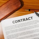 A close-up view of a contract and pen on a wooden desk, ideal for business themes.